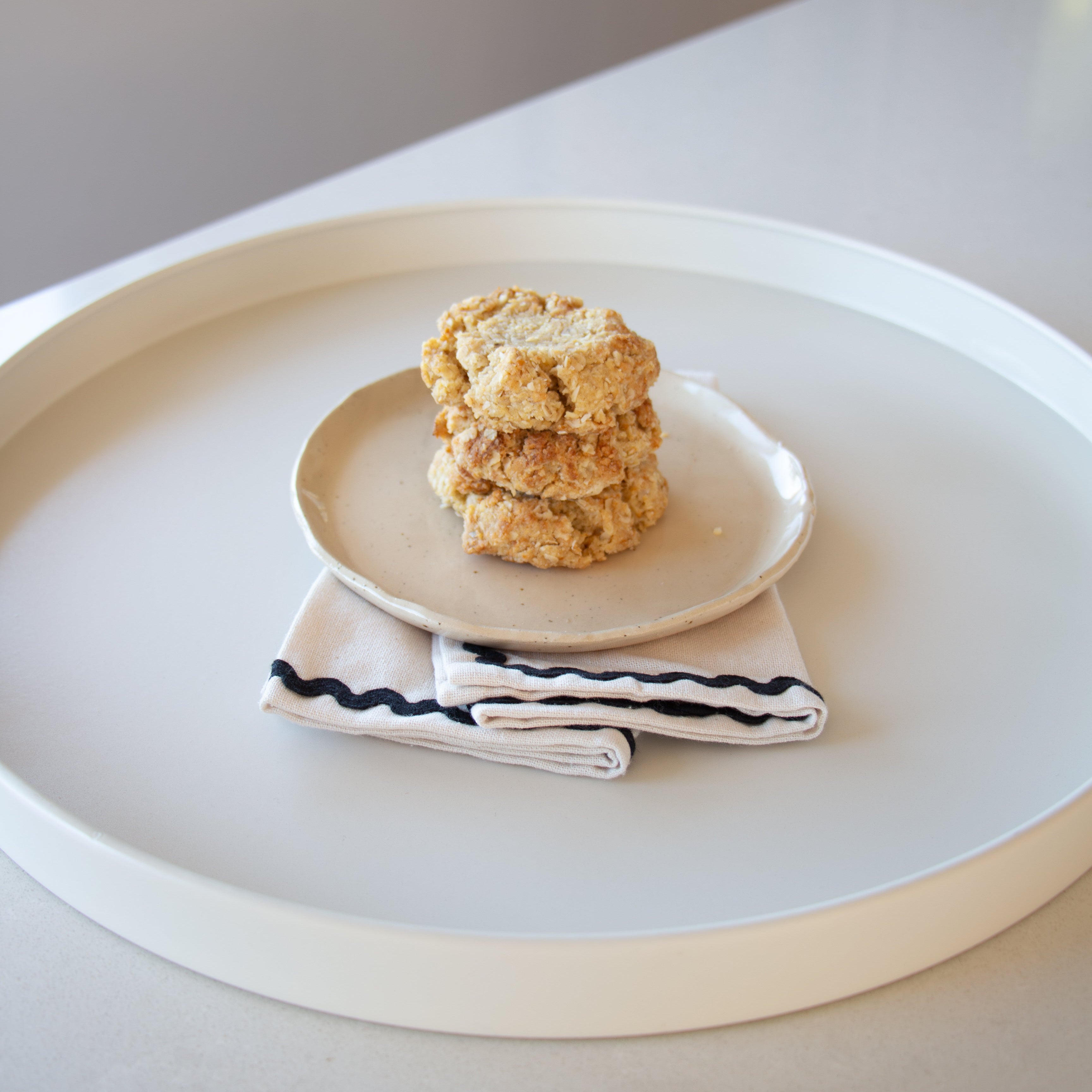 Stack of cookies on a plate with a striped napkin on a white surface