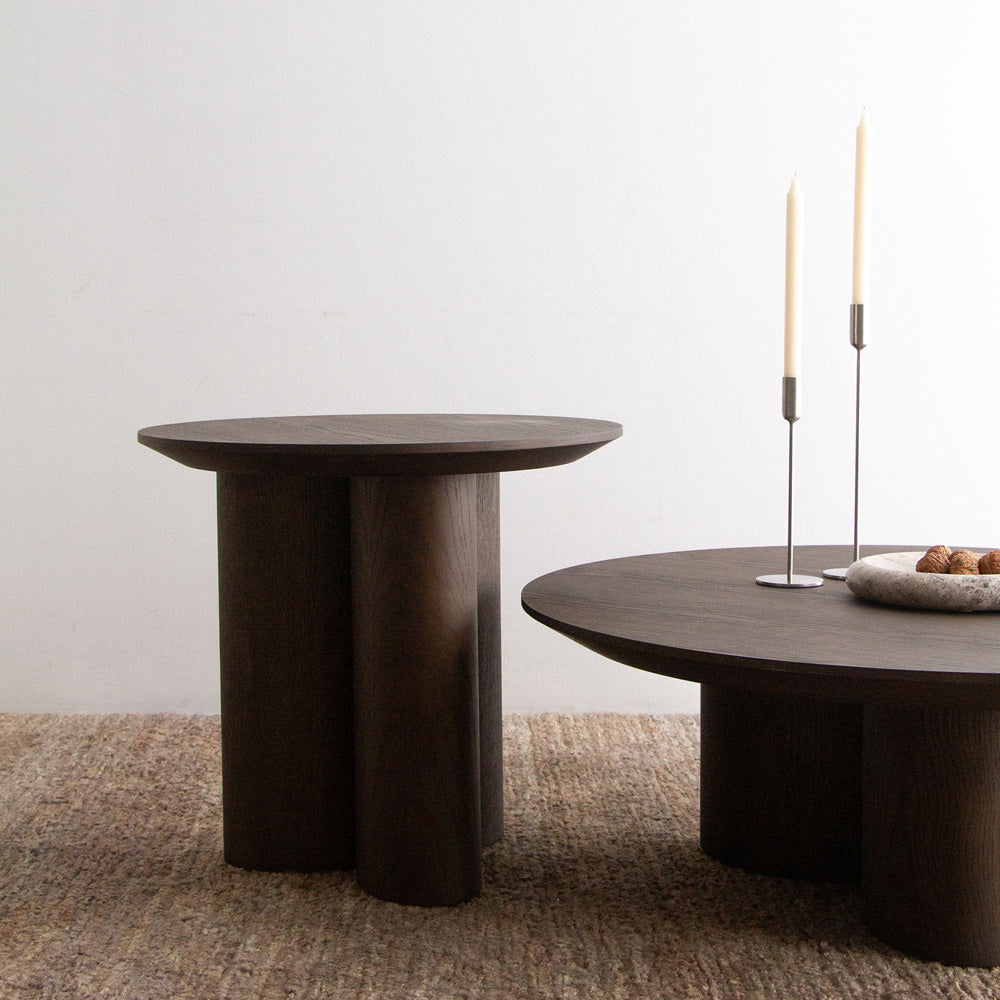 Two dark wooden tables with a minimalistic design on a neutral background