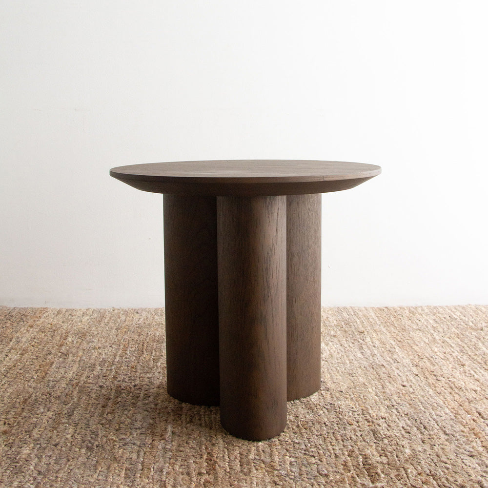 Wooden side table on a textured surface with a neutral background