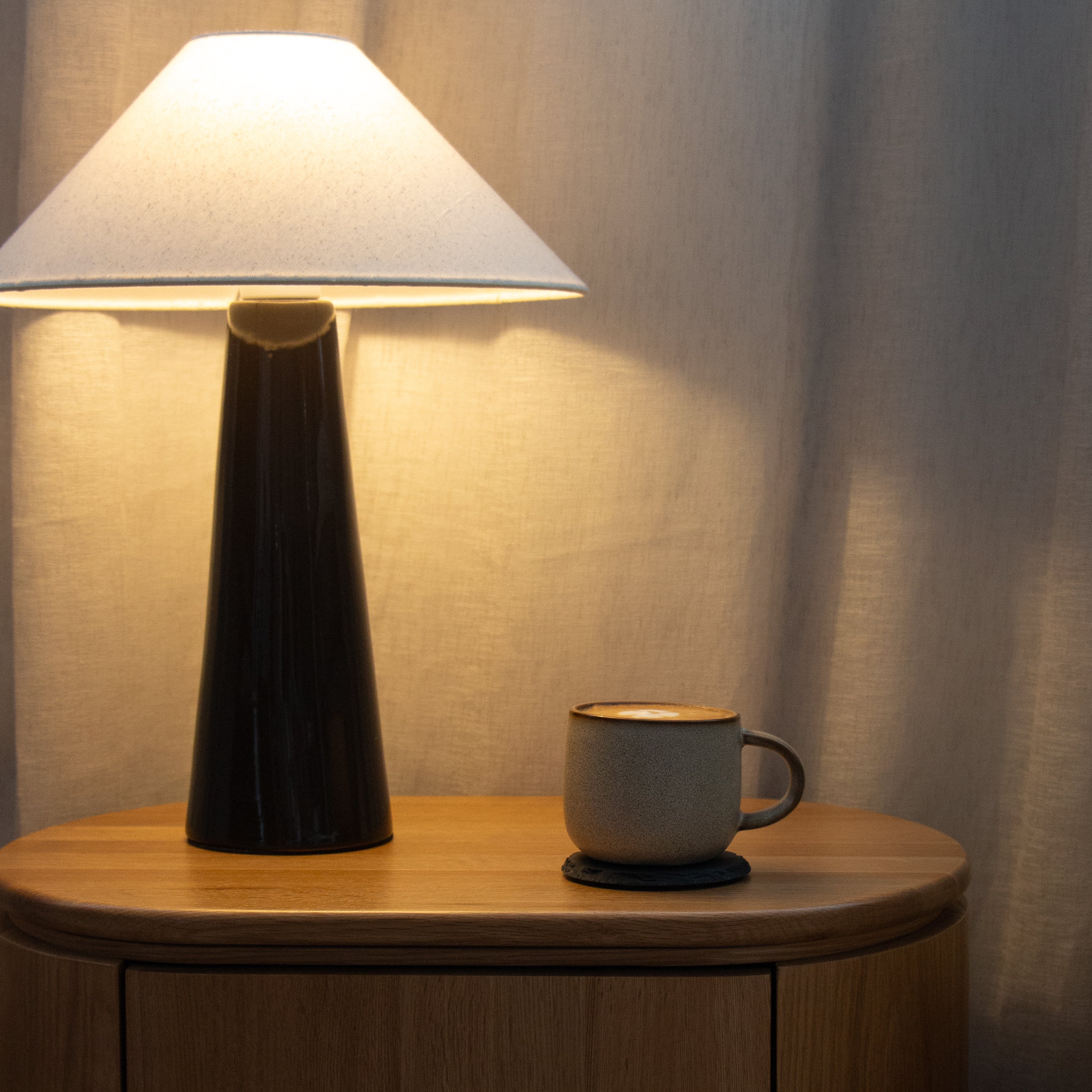 Lamp and mug on a clover wooden bedside with a soft background