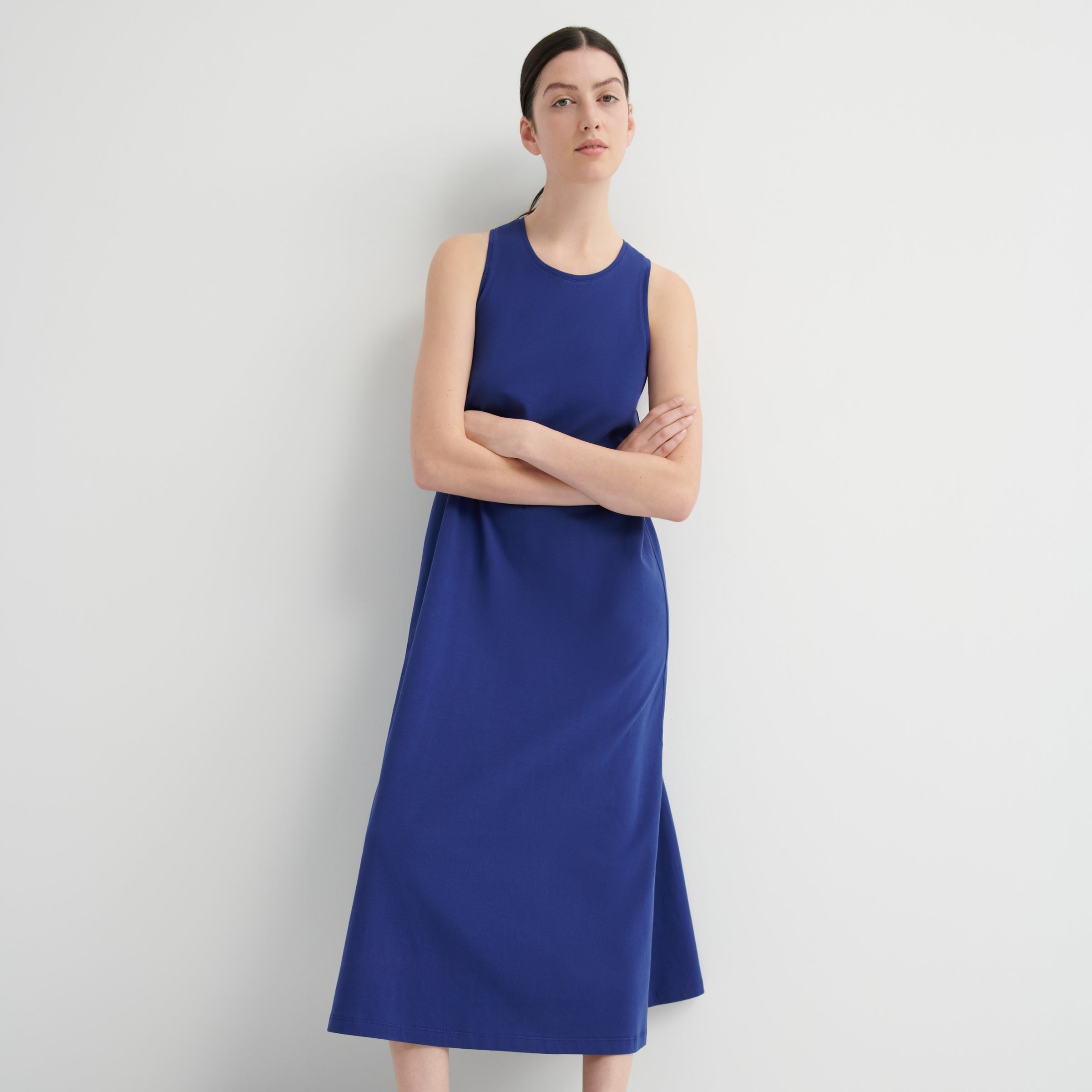 Woman wearing a blue dress standing against a white background
