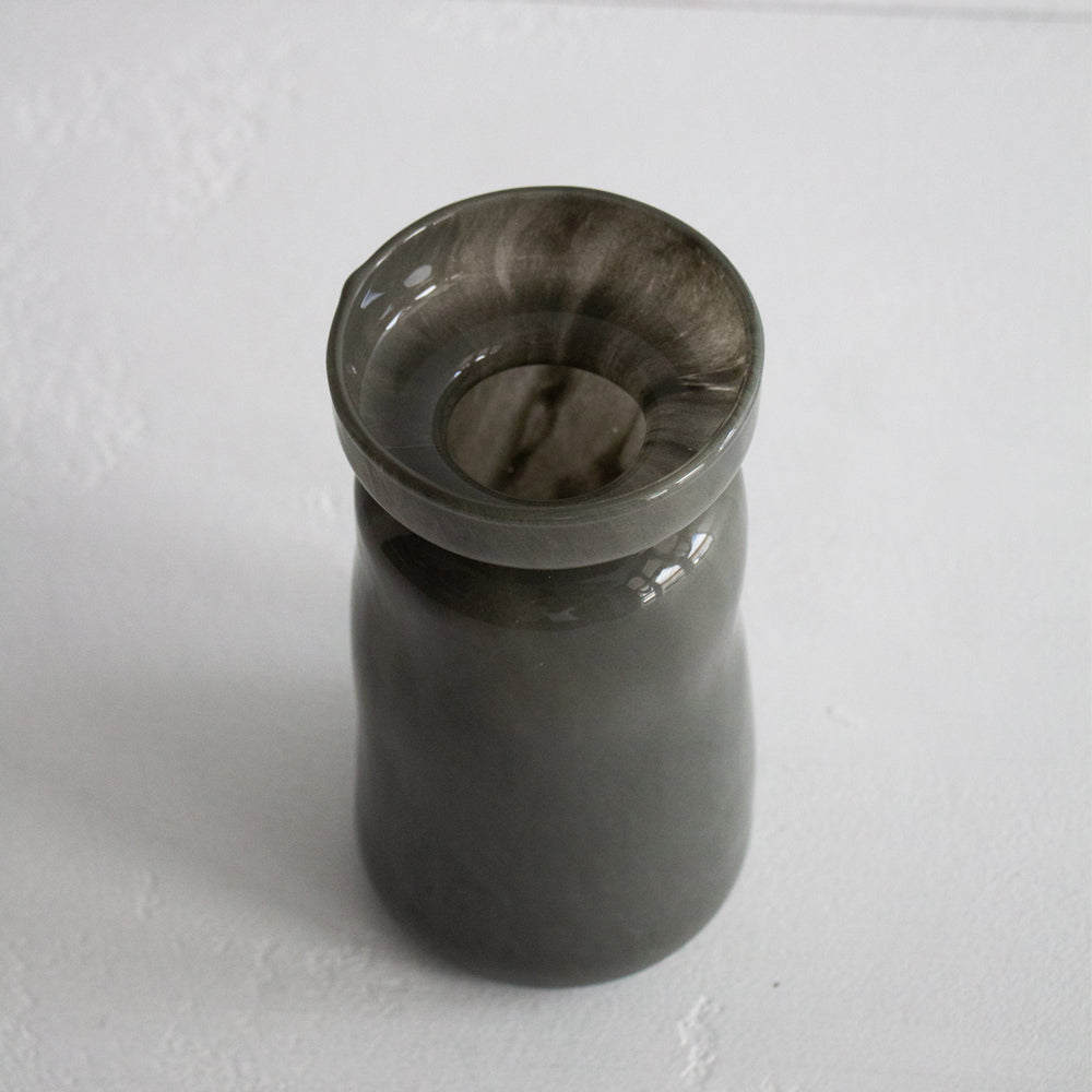 Dark green glass vase on a white background