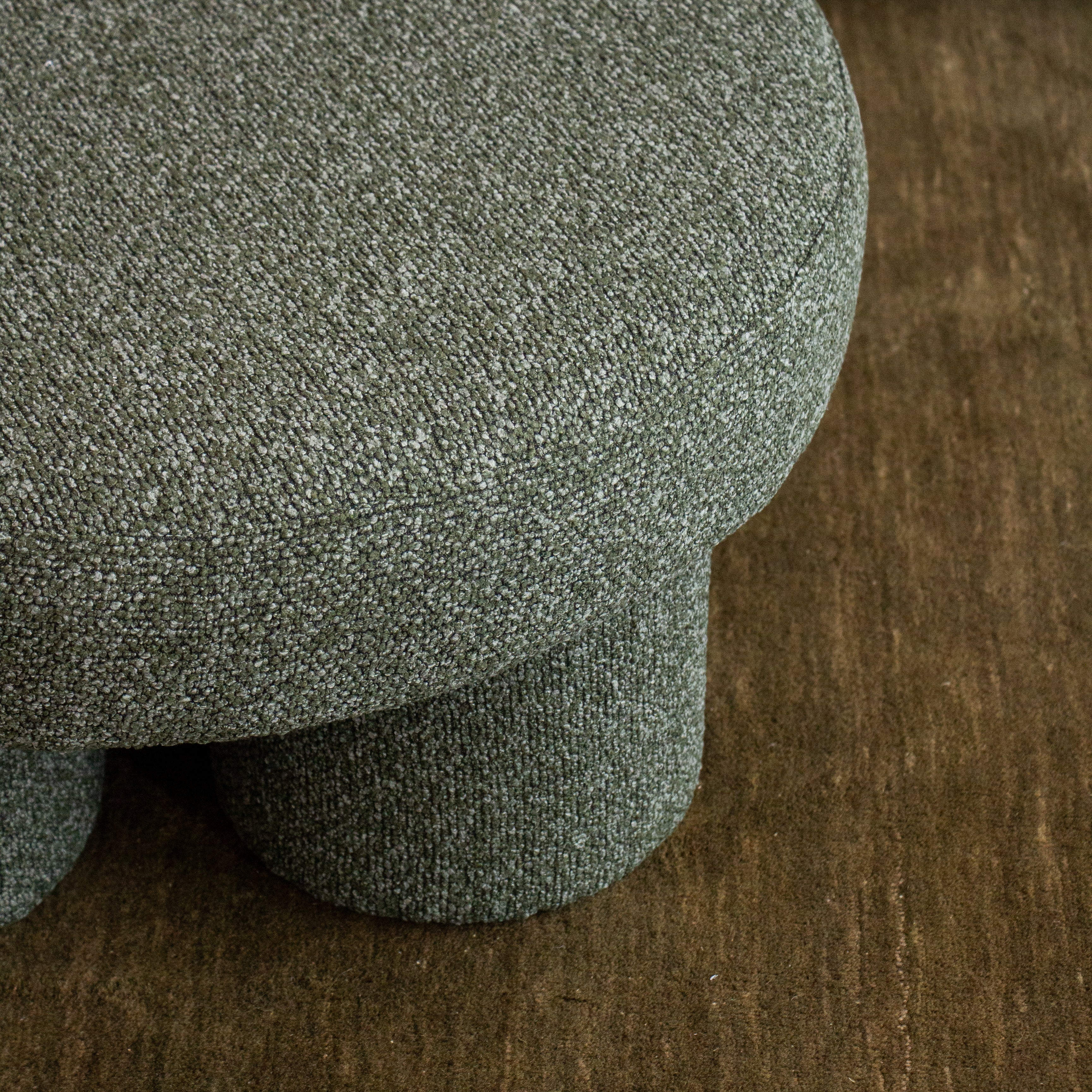 Close-up of a textured green cushion on a wooden surface
