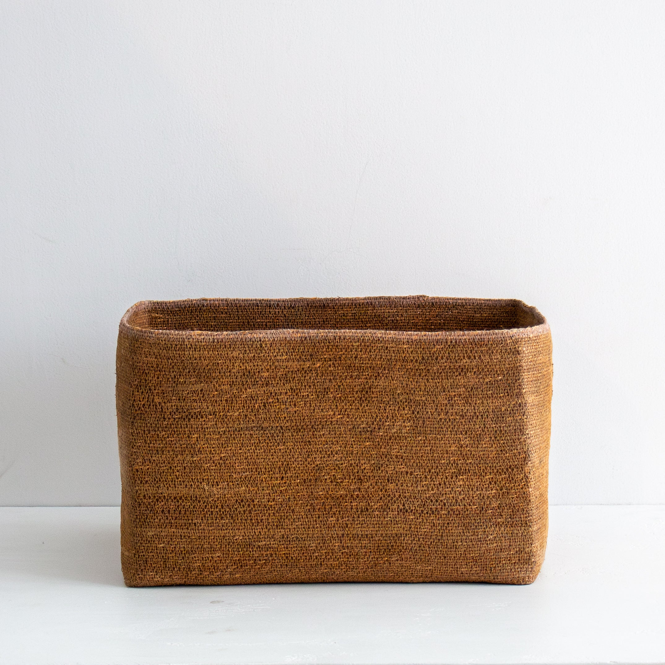 Brown woven rectangular basket on a white background